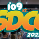 the yellow-orange io9 Vs. San Diego Comic-Con 2002 coverage badge over a photo of the con floor.